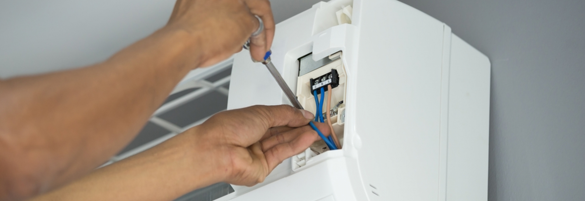 working on the electronics of a wall-mounted heat pump head