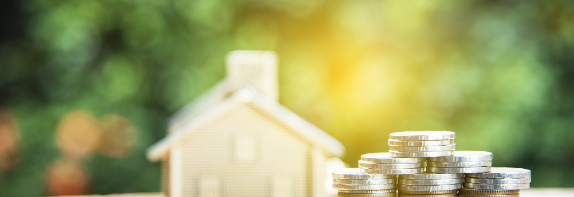 Model Home With Stack of Coins