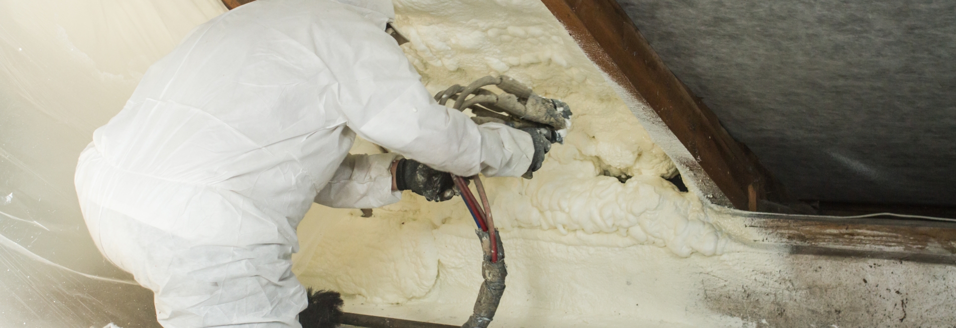 Technician Applying Spray Foam To Attic