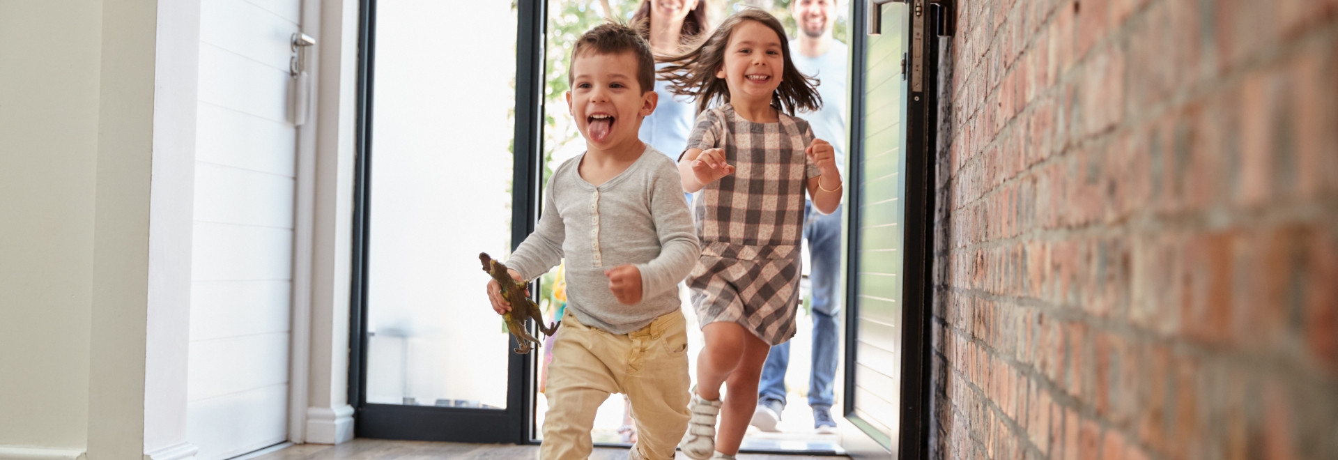 Children Running Through Front Door on Hard Wood Floors of Home