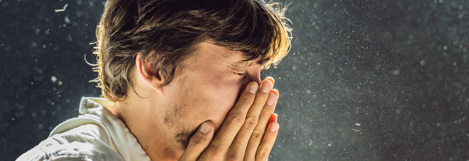 man sneezing from allergies