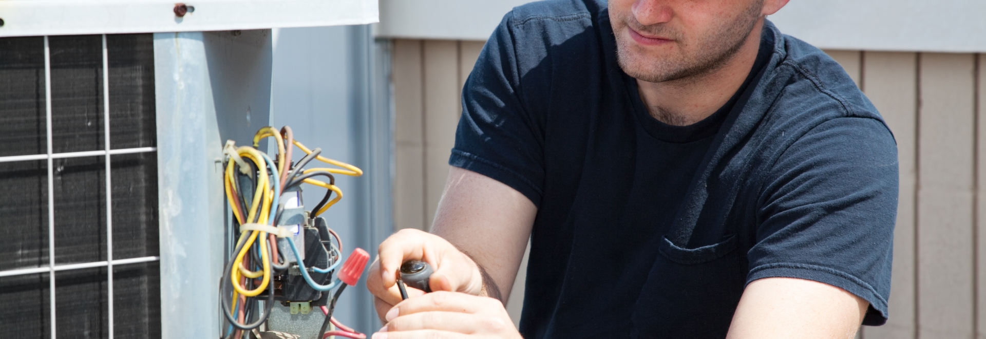 young apprentice learning on the job while repairing hvac system