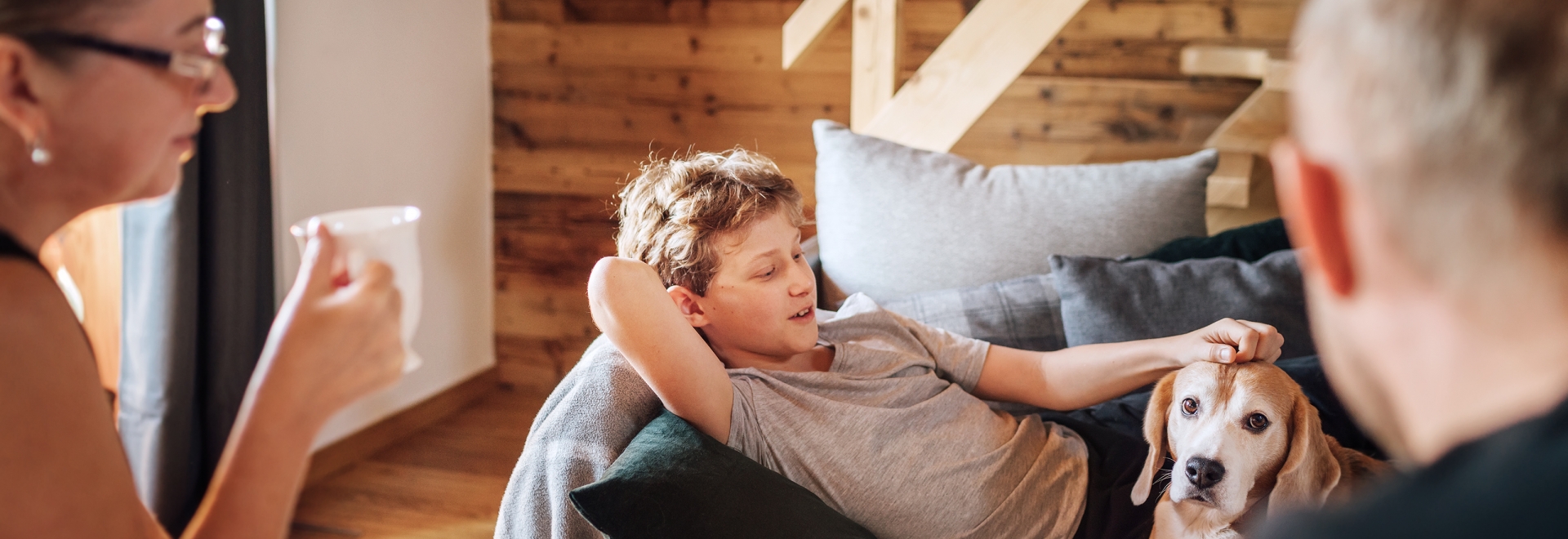 Family relaxing inside in living room with dog