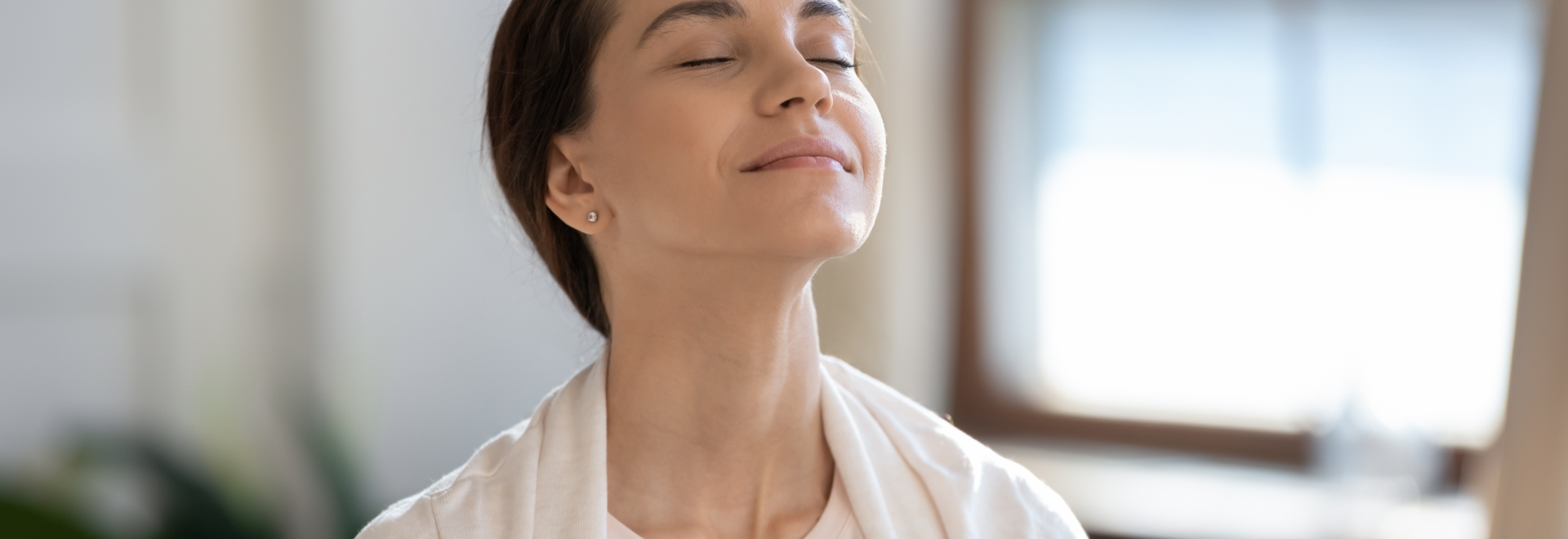 Woman breathing in clean air with her eyes closed and looking peaceful