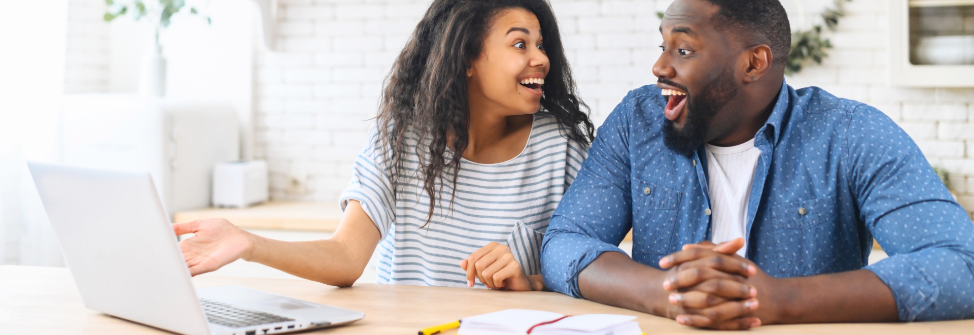 couple happy about what is on their laptop