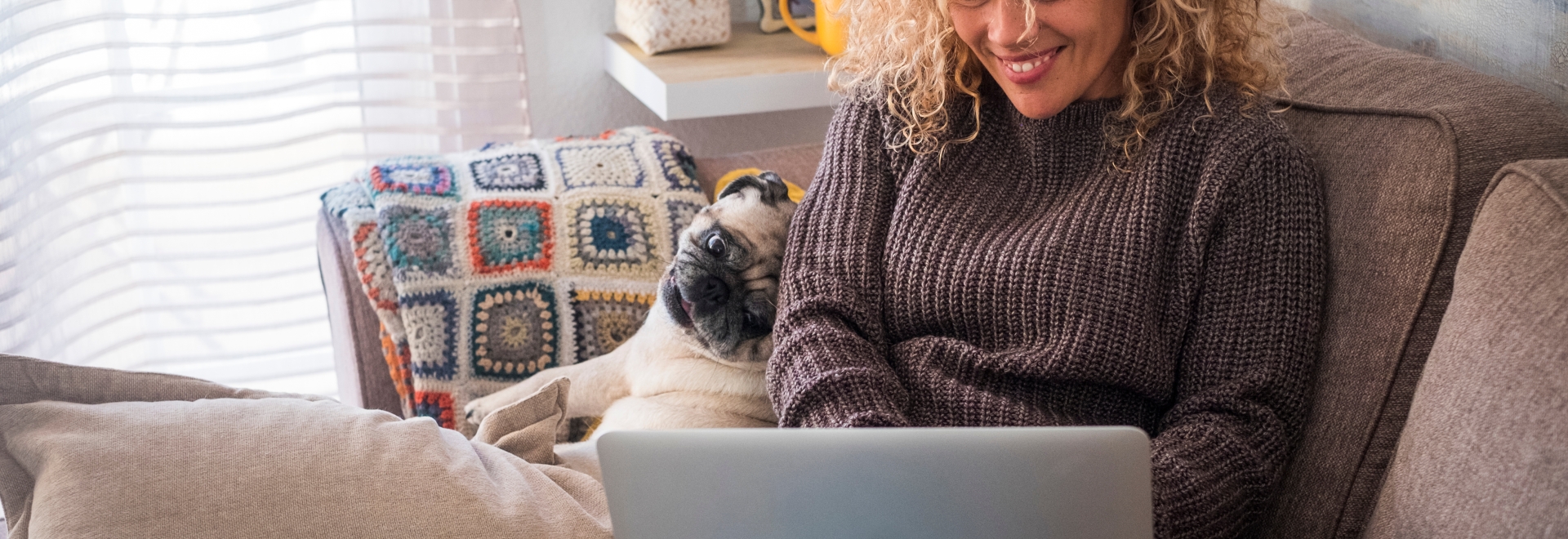 woman typing on a laptop with her dog