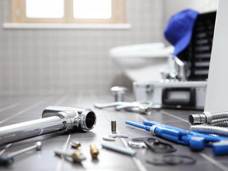 Tools littering the floor of a residential bathroom