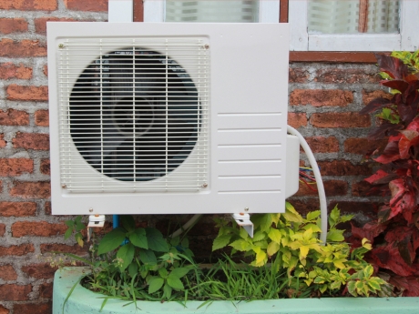 heat pump unit outside window of brick home