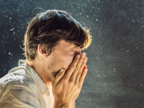 man sneezing from allergies