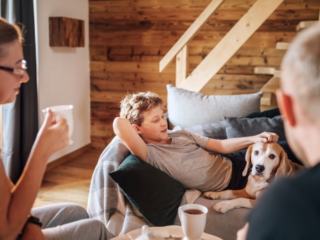 Family relaxing inside in living room with dog