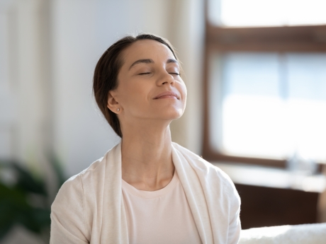 Woman breathing in clean air with her eyes closed and looking peaceful