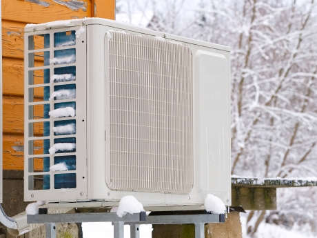 heat pump outside home in the snow