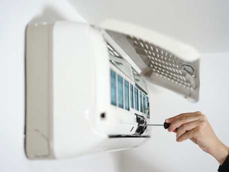 person working on a heat pump