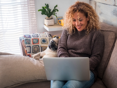 woman typing on a laptop with her dog