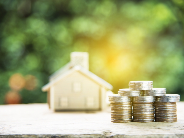 Model Home With Stack of Coins