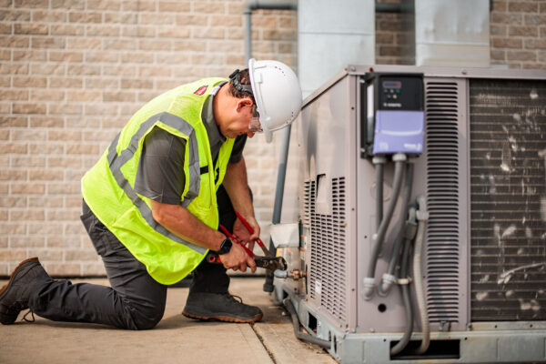 A Princeton Air technician performs commercial HVAC maintenance on an outdoor HVAC unit.