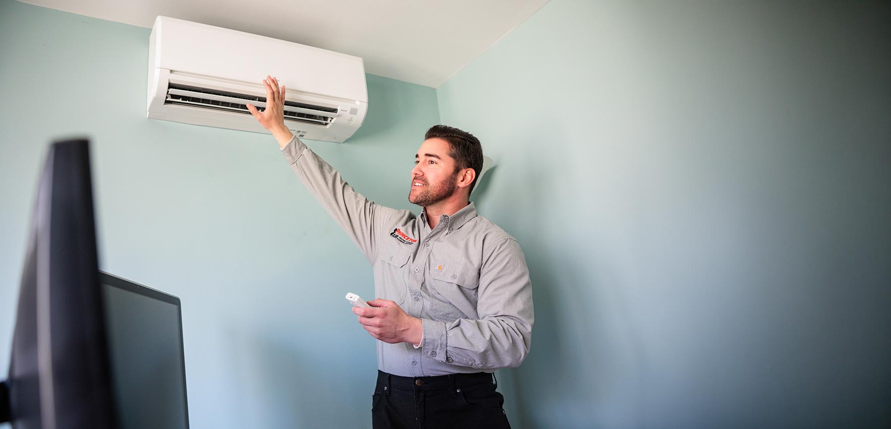 a princeton air technician is in a home testing a ductless mini split air conditioner