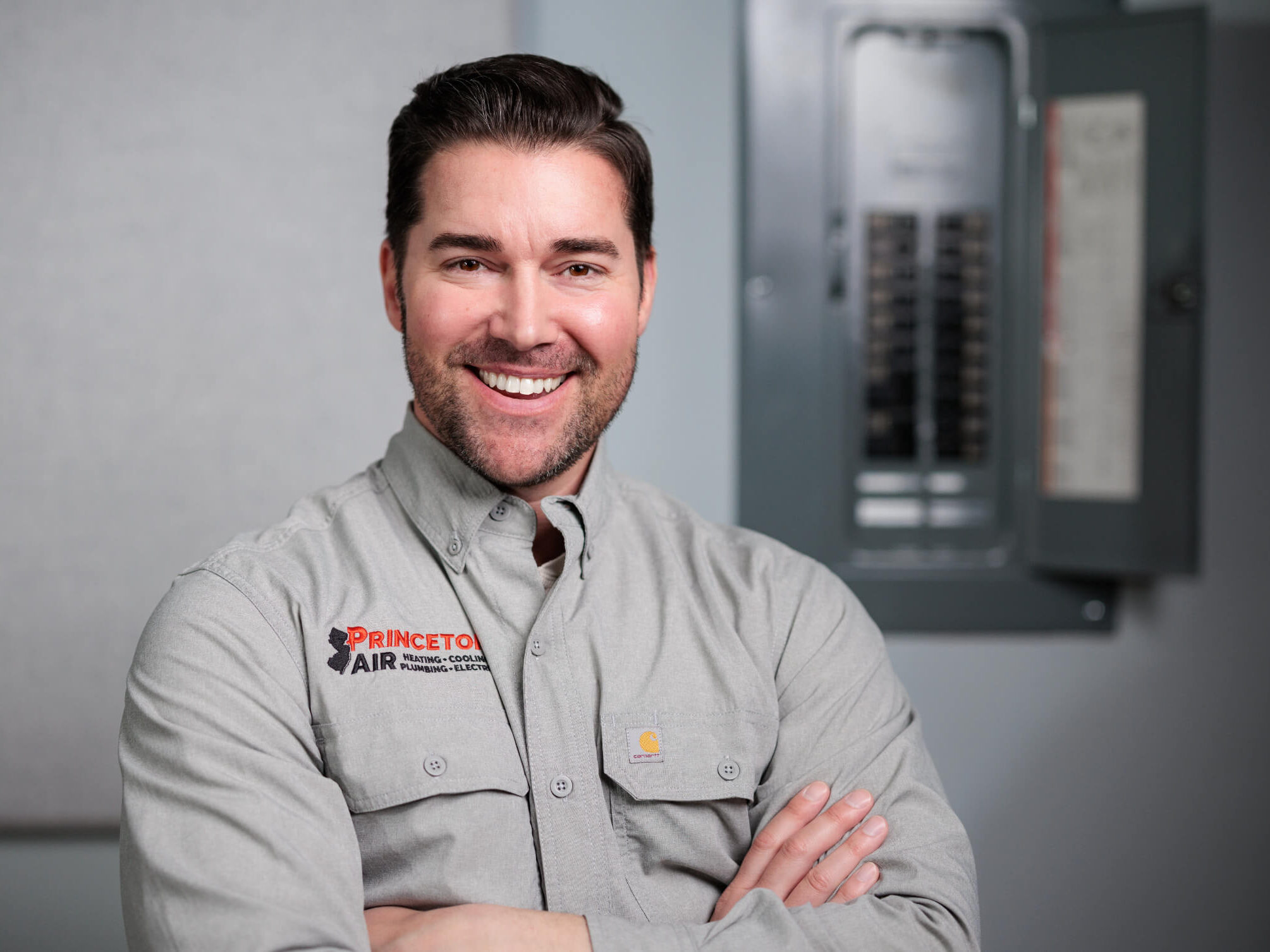 Smiling PA electrician beside panel