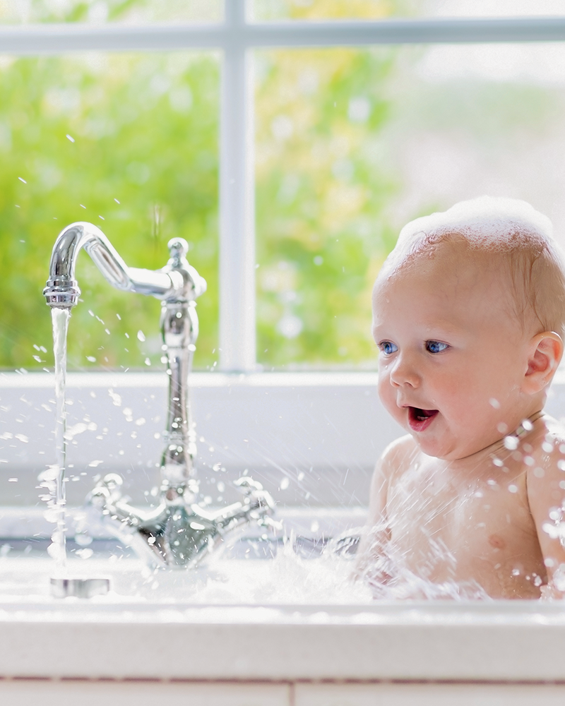 Baby enjoying a bath after a visit from Princeton Air Plumbing