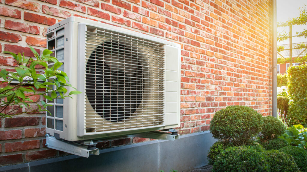 Heat pump mounted on a red brick wall